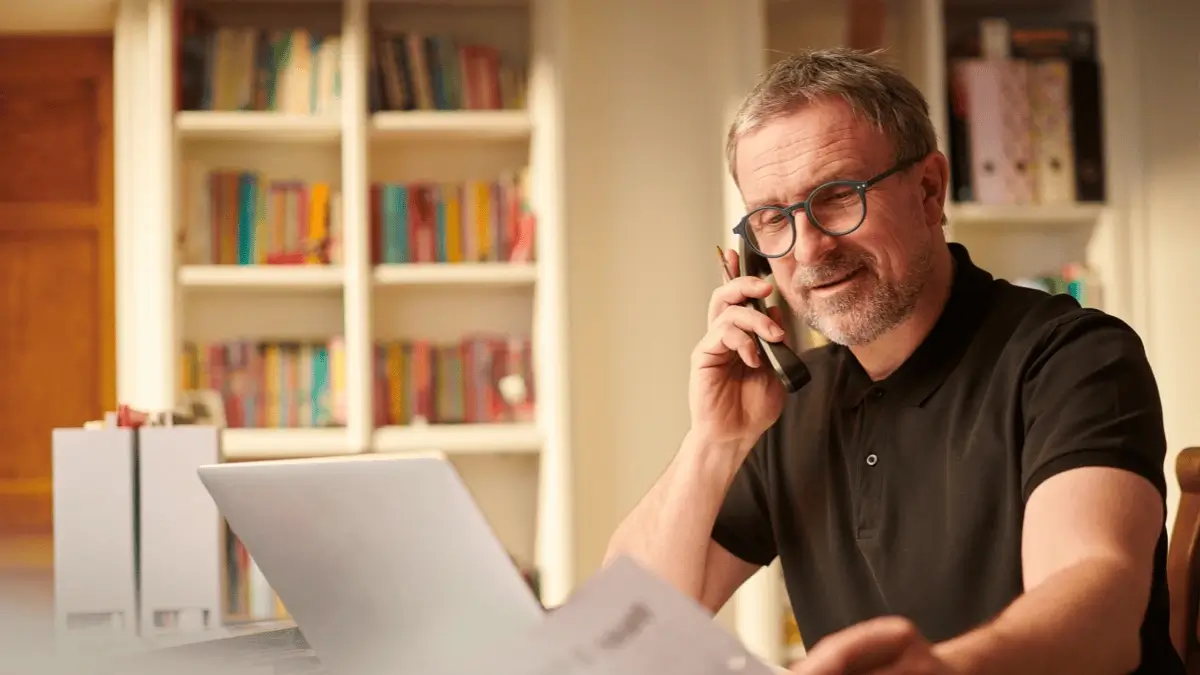 Cmall business owner working calmly on laptop and phone, representing effortless visibility with SnapPoster.